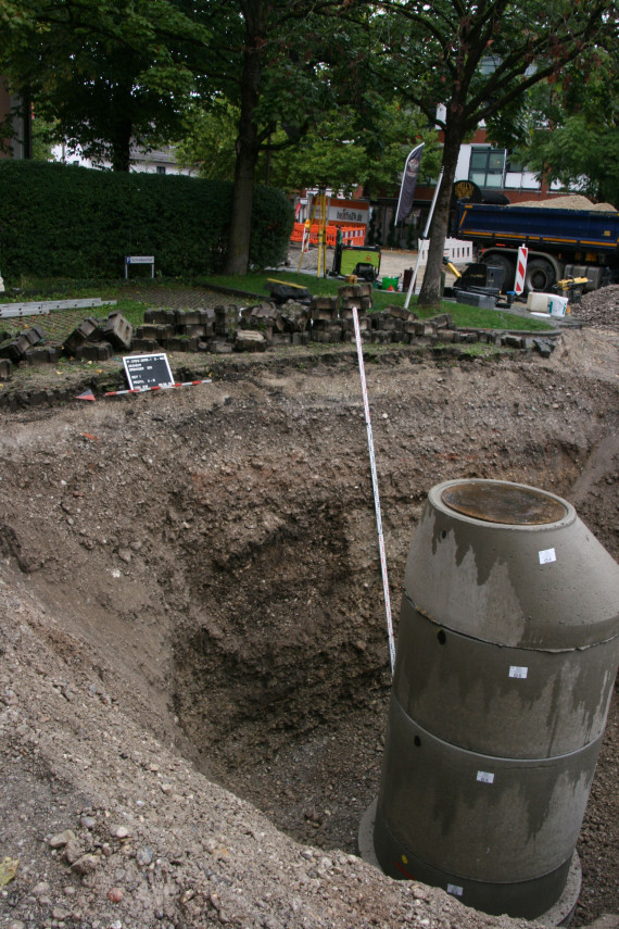 Baugrube mit Profil eines verfpllten Brunnenschachtes an der linken Kieswand